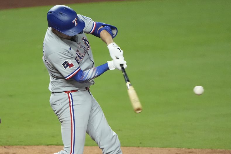 Kyle Higashioka, de los Rangers de Texas, batea un doble de tres carreras en el encuentro ante los Reales de Kansas City, el miércoles 20 de agosto de 2025 (AP Foto/Charlie Riedel)