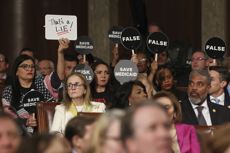 Demócratas sostienen letreros de protesta mientras el presidente estadounidense Donald Trump pronuncia un discurso ante una sesión conjunta del Congreso, en el Capitolio, Washington, el martes 4 de marzo de 2025. (Win McNamee/Pool Photo vía AP)