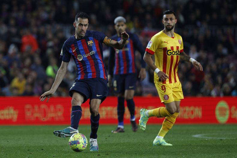 Sergio Busquets del Barcelona pasa el balón frente a Valentín Castellanos durante el partido por la Liga española, el lunes 10 de abril de 2023. (AP FotoJoan Monfort)
