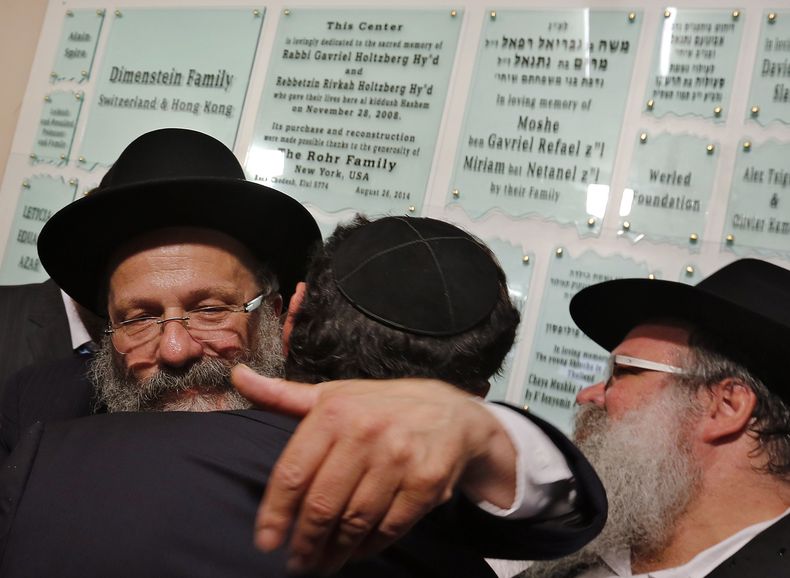 Rabino Nachman Holtzberg, padre del rabino Gavriel Holtzberg, quien muri&oacute; en los ataques terroristas de 2008 en Mumbai, abraza a un miembro de la comunidad durante la reapertura del Centro Jabad en Mumbai, India, martes 26 de agosto de 2014. Rabino