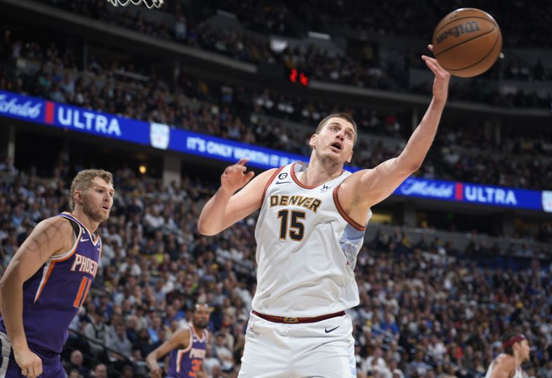 El pívot serbio Nikola Jokic, de los Nuggets de Denver, alcanza un rebote frente a Jock Landale, de los Suns de Phoenix, en el encuentro de playoffs disputado el martes 9 de mayo de 2023 (AP Foto/David Zalubowski)
