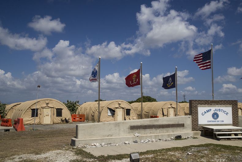 Archivo - En esta fotografía revisada por las autoridades militares de Estados Unidos, una bandera nacional estadounidense y otras ondean frente a carpas militares el 18 de abril de 2019 en la base naval de Guantánamo, Cuba. (AP Foto/Alex Brandon, Archivo)