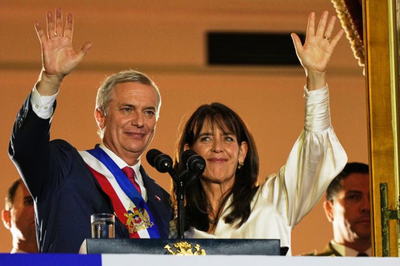 El presidente de Chile, José Antonio Kast, y su esposa, María Pía Adriasola, saludan a sus seguidores desde el balcón del palacio presidencial de La Moneda tras su investidura en Santiago de Chile, el miércoles 11 de marzo de 2026. (AP Foto/Esteban Félix)