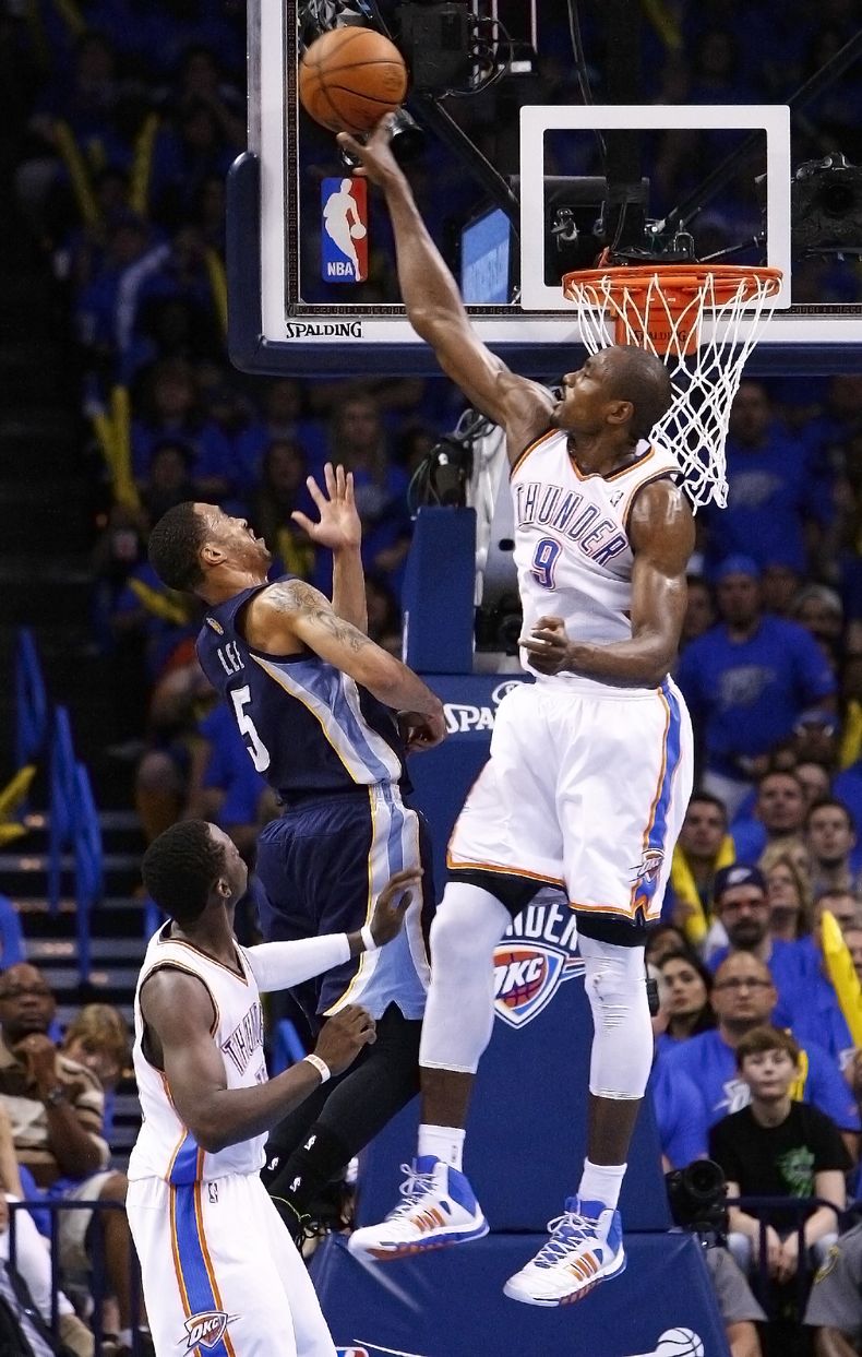 Serge Ibaka (9), del Thunder de Oklahoma City, topona un lanzamiento de Courtney Lee (5), de los Grizzlies de Memphis, durante el tercer periodo en Oklahom City, el s&aacute;bado 19 de abril de 2014. El Thunder gan&oacute; 100-86 el partido inicial de la