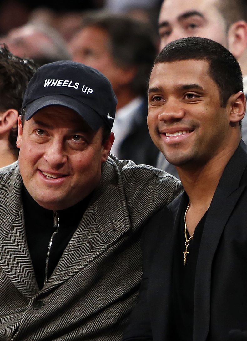 El quarterback de los Seahawks de Seattle, Russell Wilson, derecha, posa para una foto en un partido de la NBA entre los Mavericks de Dallas y Knicks de Nueva York el lunes, 24 de febrero de 2014, en Nueva York. (AP Photo/Jason DeCrow)