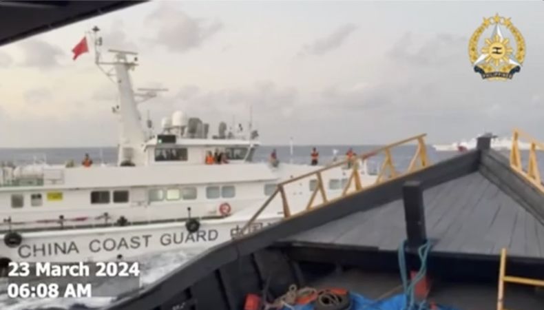 En esta imagen, tomada de un video distribuido por las Fuerzas Armadas de Filipinas, un barco de la Guardia Costera de China bloquea el paso al buque de reabastecimiento fiIipino Unaizah May 4 en las inmediaciones de un disputado atolón, en el Mar de la China Meridional, el 23 de marzo de 2024. (Fuerzas Armadas de Filipinas vía AP)