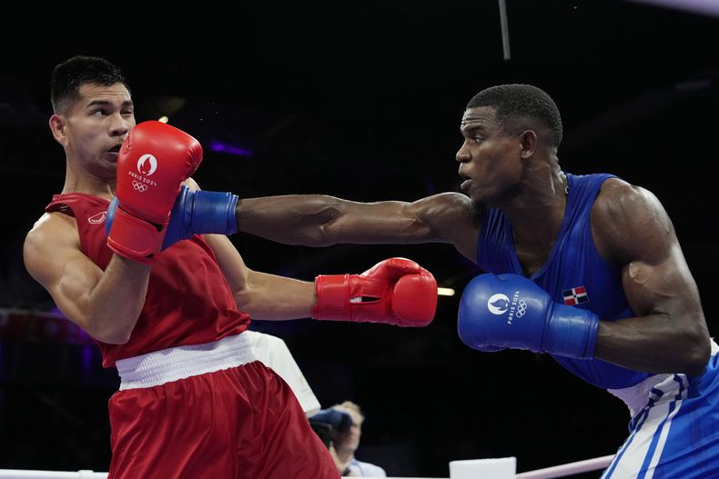 El dominicano Cristian Pinales golpea al tailandés Weerapon Jongjoho en su combate en la categoría de los 80 kilogramos de los Juegos Olímpicos, el sábado 27 de julio de 2024, en Villepinte, Francia. (AP Foto/Ariana Cubillos)