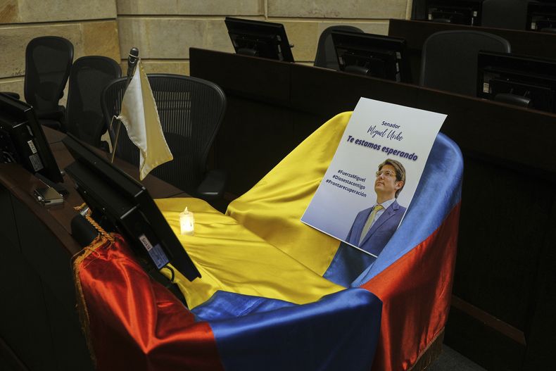 ARCHIVO - Un folleto muestra la imagen del senador colombiano Miguel Uribe Turbay sobre una bandera colombiana que cubre su escaño en el Congreso, en Bogotá, Colombia, el 9 de junio de 2025. (AP Foto/Iván Valencia, Archivo)
