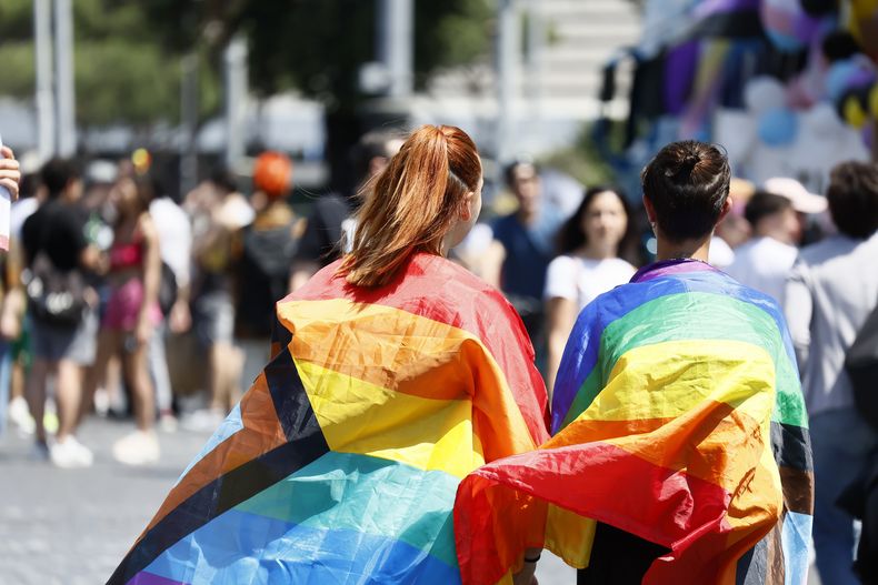 ARCHIVO – Personas envueltas en banderas del arco iris participan en el desfile del Orgullo LGBTQ+ en Roma, el sábado 10 de junio de 2023. (Cecilia Fabiano/LaPresse vía AP, Archivo)