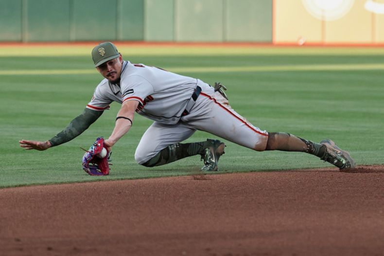 El dominicano Willy Adames, de los Gigantes de San Francisco, intenta detener un rodado en el juego del sábado 16 de mayo de 2026 ante los Atléticos (AP Foto/Sara Nevis)
