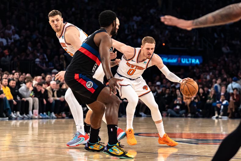 Donte DiVincenzo (0), de los Knicks de Nueva York, conduce el balón con la marca defensiva de Chimezie Metu, de los Pistons de Detroit, durante la primera mitad del juego de baloncesto de la NBA, en Nueva York, el lunes 25 de marzo de 2024. (AP Foto/Peter K. Afriyie)