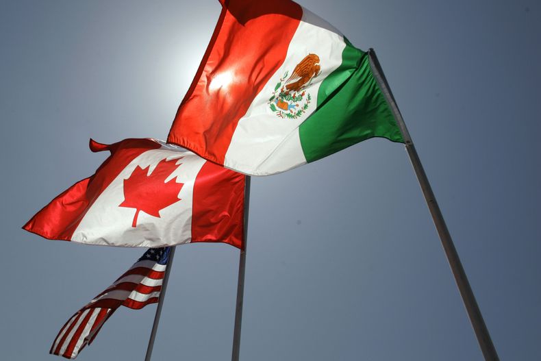 ARCHIVO - Banderas nacionales de Estados Unidos, Canadá y México ondean en la brisa en Nueva Orleans, donde los líderes del Tratado de Libre Comercio en América del Norte se reunieron el 21 de abril de 2008. (AP Foto/Judi Bottoni, Archivo)