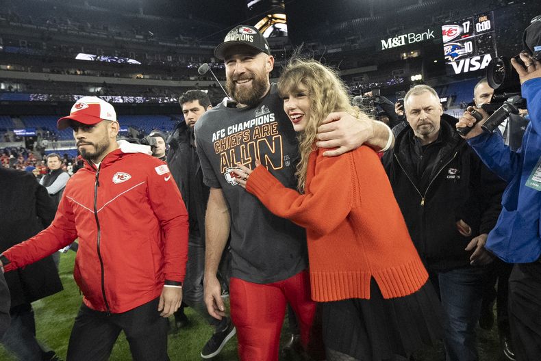 ARCHIVO - El ala cerrada de los Chiefs de Kansas City, Travis Kelce, y Taylor Swift caminan juntos después de un partido de fútbol americano de la NFL por el Campeonato de la AFC entre los Chiefs y los Ravens de Baltimore, el 28 de enero de 2024, en Baltimore. (Foto AP/Julio Cortez, archivo)