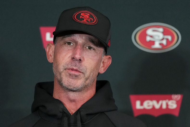 Kyle Shanahan, head coach de los 49ers de San Francisco, habla con los representantes de los medios de comunidación de cara al entrenamiento del lunes 7 de septiembre de 2026, en Melbourne, Australia, como preparación para el partido de la NFL contra los Rams de Los Ángeles. (AP Foto/Asanka Brendon Ratnayake)