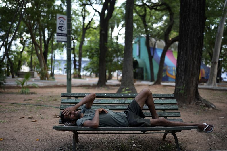 Un hombre que lava automóviles descansa sobre una banca en la plaza Uruguay durante una tarde cálida, el viernes 17 de enero de 2025, en Asunción, Paraguay. (AP Foto/Jorge Saenz)