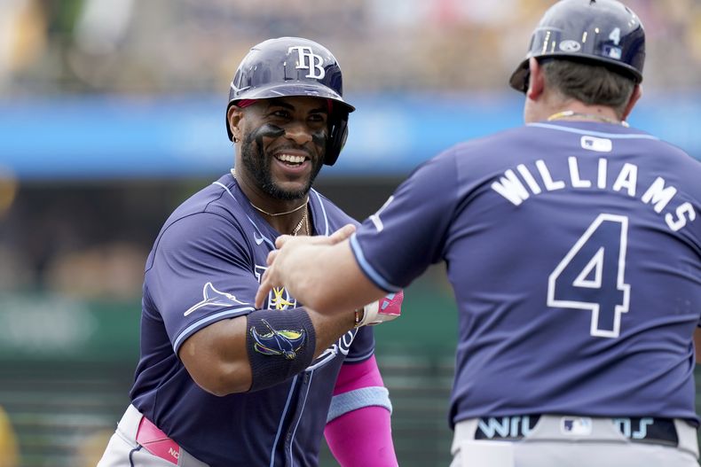 El dominicano de los Rays de Tampa Bay, Yandy Díaz (izquierda) es felicitado por el entrenador de tercera base Brady Williams (derecha) mientras recorre las almohadillas luego de impactar un jonrón durante la primera entrada del juego de béisbol ante los Piratas de Pittsburgh, el domingo 23 de junio de 2023, en Pittsburgh. (AP Foto/Matt Freed)