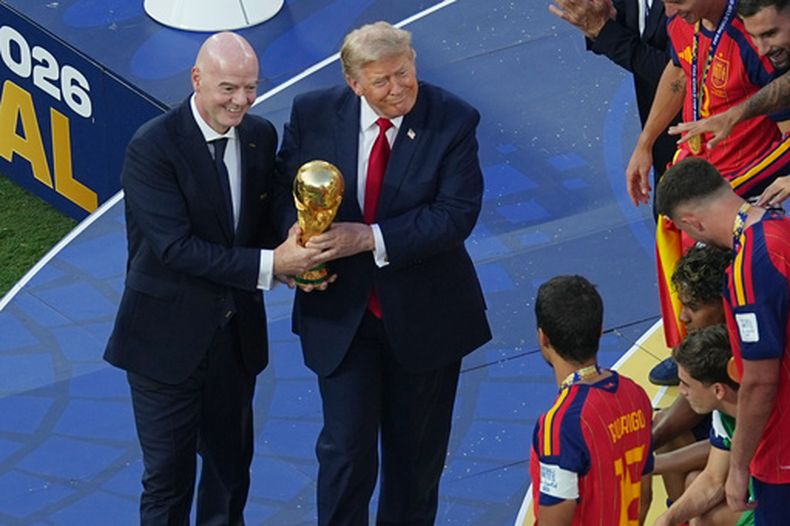 El presidente de la FIFA Gianni Infantino y el presidente de los Estados Unidos Donald J. Trump presentan el trofeo de campeón de la Copa del Mundo a Rodri después de que España venció a Argentina en la final del domingo 19 de julio del 2026. (AP Foto/Matt Rourke)