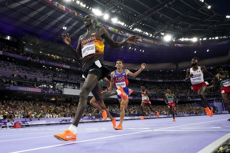 El ugandés Joshua Cheptegei festeja luego de ganar los 10.000 metros en los Juegos Olímpicos, el viernes 2 de agosto de 2024, en Saint-Denis, Francia (AP Foto/David J. Phillip)