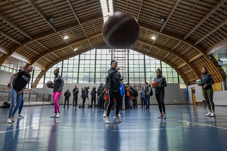 Las jugadoras cubanas de hockey, de izquierda a derecha Yakira Guillén, Lismary González, Geidy Morales, Helec Carta y Jennifer Martínez, quienes compitieron en los Juegos Panamericanos, juegan baloncesto con otros deportistas cubanos, quienes todos desertaron la delegación cubana después de los juegos y están buscando refugio en Chile, en el gimnasio municipal de Lo Barnechea, en Santiago, Chile, el viernes 10 noviembre de 2023. (AP Foto/Esteban Felix)