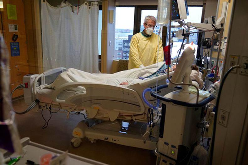 ARCHIVO - Steve Grove, capellán del Centro Médico del Condado Hennepin, ora en el cuarto de un paciente con COVID-19, el 10 de diciembre de 2021, en Minneapolis. (AP Foto/Charlie Neibergall, Archivo)