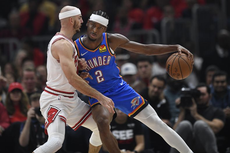 Shai Gilgeous-Alexander, del Thunder de Oklahoma City, busca pasar frente a Alex Caruso, de los Bulls de Chicago, el miércoles 25 de octubre de 2023 (AP Foto/Paul Beaty)