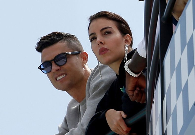 ARCHIVO - Cristiano Ronaldo, a la izquierda, y su pareja, Georgina Rodriguez, miran la segunda sesión de entrenamientos en el circuito de Mónaco en Mónaco, el 23 de mayo de 2019. (AP Foto/Luca Bruno, Archivo)