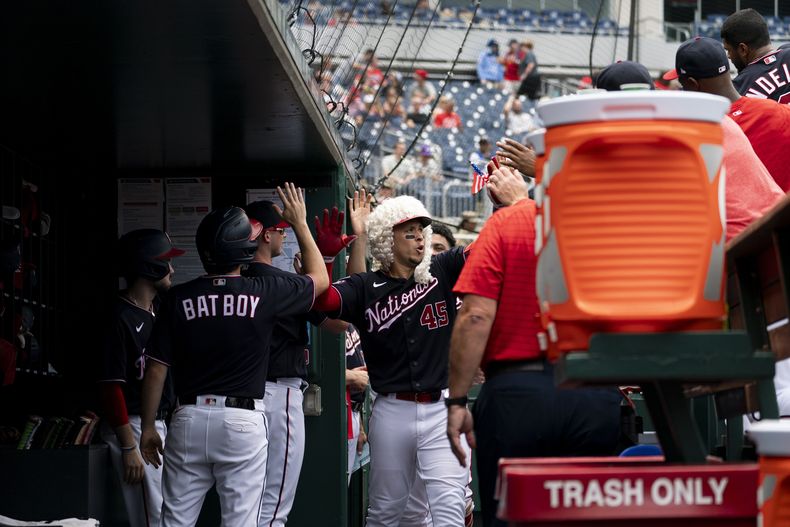 Joey Meneses (45) (centro) de los Nacionales de Washington celebrar tras batear un jonrón ante los Rangers de Texas, el domingo 9 de julio de 2023, en Washington. (AP Foto/Stephanie Scarbrough)