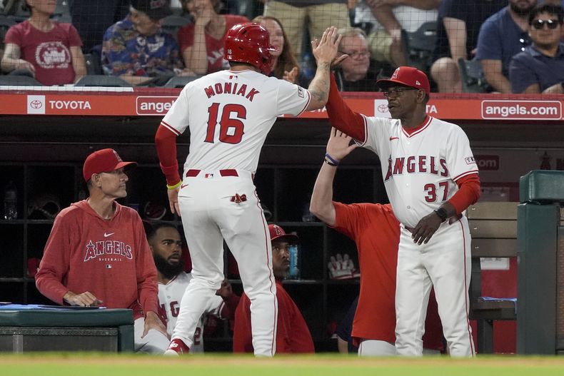 Mickey Moniak, de los Angelinos de Los Ángeles, festeja con el manager Ron Washington luego de anotar ante los Atléticos de Oakland, el martes 25 de junio de 2024 (AP Foto/Ryan Sun)
