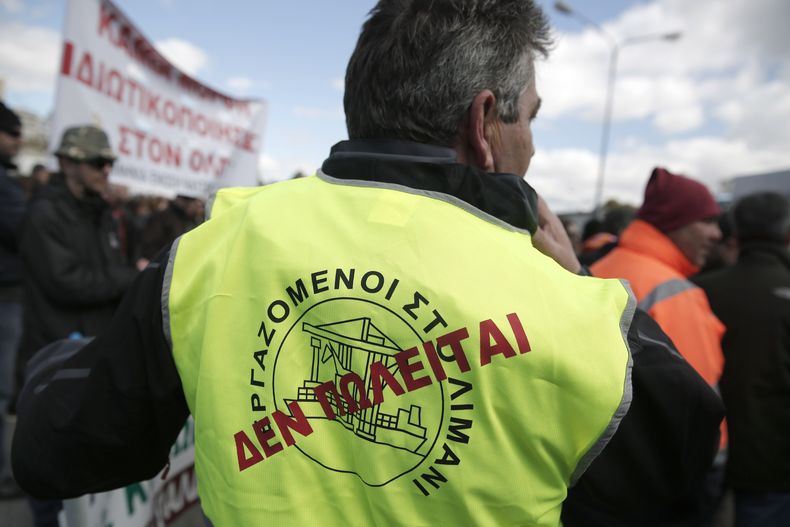 Un trabajador portuario con un chaleco que dice "no se vende" participa en una protesta contra los planes del gobierno de ampliar la privatizaci&oacute;n del muelle del Pireo, el de mayor tr&aacute;fico en Grecia, en el Pereo, el martes 11 de ma