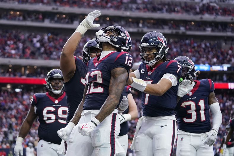 El wide receiver de lo Texans de Houston Nico Collins (12) celebra junto a sus compañeros de equipo luego de una recepción de touchdown frente a los Broncos de Denver en la segunda mitad de un juego de la NFL, el domingo 3 de diciembre de 2023, en Houston. (AP Foto/Eric Christian Smith)