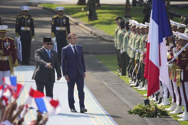 El presidente de Francia, Emmanuel Macron, en el centro a la derecha, y el presidente de Indonesia, Prabowo Subianto, en el centro a la izquierda, pasa revista a una guardia de honor antes de su reunión en el palacio Merdeka en Yakarta, Indonesia, el miércoles 28 de mayo de 2025. (AP Foto/Achmad Ibrahim)