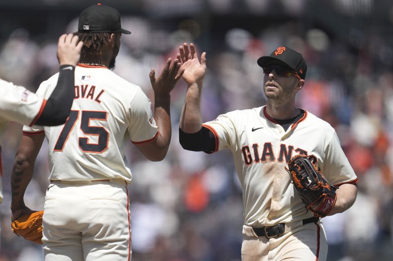 El lanzador de los Gigantes de San Francisco, Camilo Doval (75), celebra con el jardinero izquierdo Austin Slater (13) después de que los Gigantes derrotaran a los Astros de Houston en San Francisco, el miércoles 12 de junio de 2024. (AP Foto/Jeff Chiu)