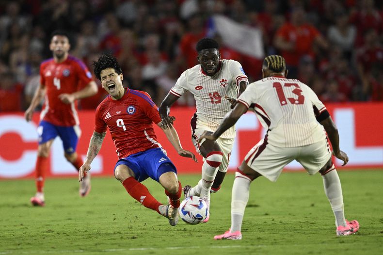 El chileno Víctor Dávila (9) tras recibir una falta del canadiense Alphonso Davies (19) durante el partido del Grupo A de la Copa América, el sábado 29 de junio de 2024, en Orlando. (AP Foto/Phelan Ebenhack)