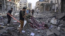 Varios palestinos recogen cadáveres de entre los escombros tras un bombardeo israelí, el miércoles 11 de octubre de 2023, en la Ciudad de Gaza. (AP Foto/Fatima Shbair)