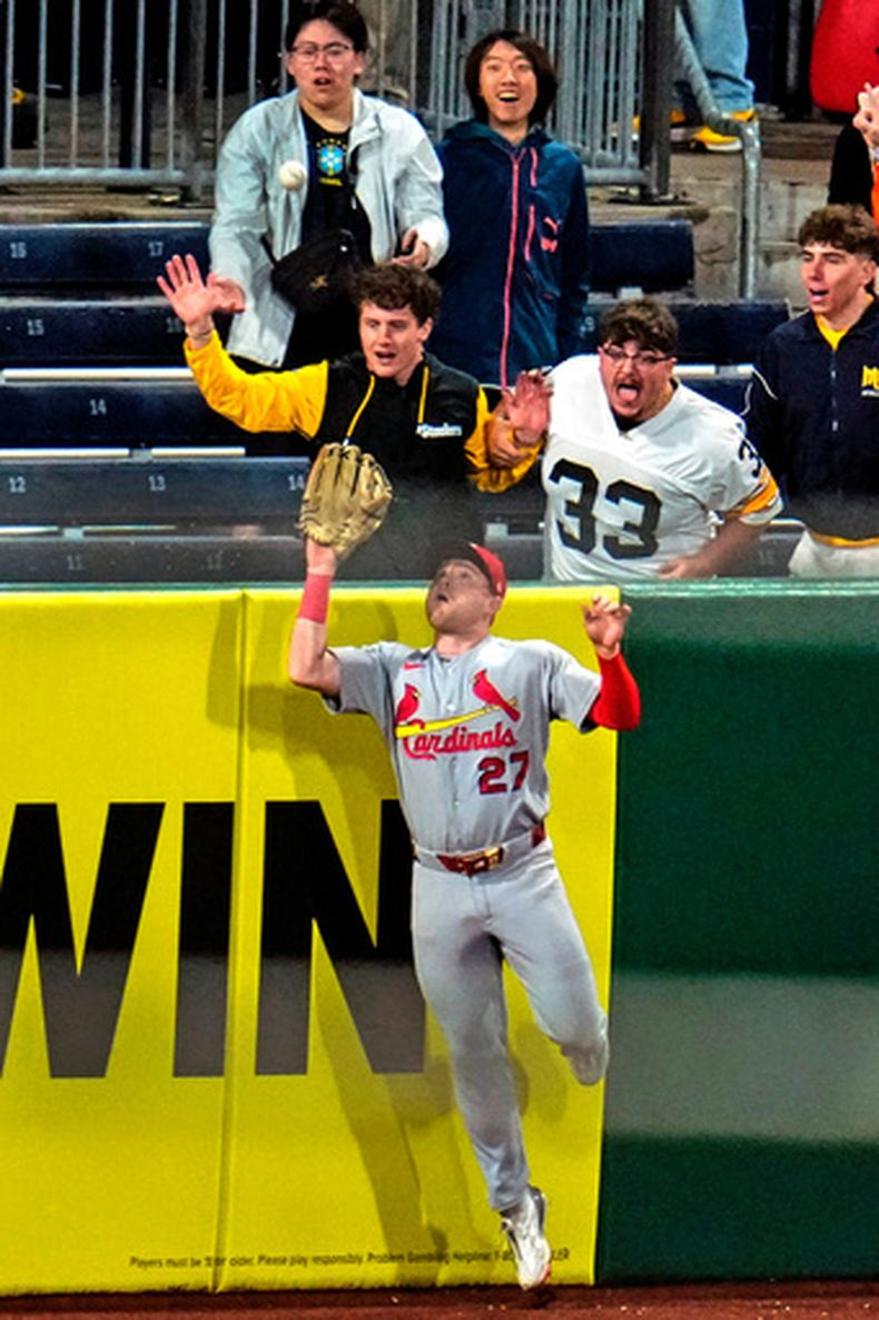 St. Louis Cardinals left fielder Nathan Church (27), jardinero izquierdo de los Cardenales de San Luis, se alza para atrapar la pelota y robarle un potencial jonrón de Nick Gonzales, de los Piratas de Pittsburgh, para terminar el partido de béisbol de Grandes Ligas el miércoles 29 de abril de 2026, en Pittsburgh. (AP Foto/Gene J. Puskar)