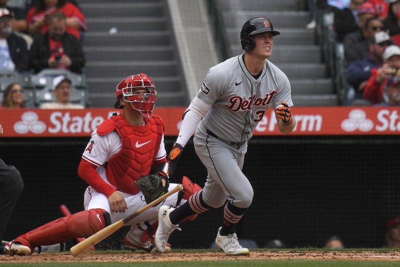 Kerry Carpenter, de los Tigres de Detroit, a la derecha, batea un doble productor de dos carreras mientras el receptor de los Angelinos de Los Ángeles, Logan OHoppe, observa durante la segunda entrada de un juego de béisbol el domingo 4 de mayo de 2025, en Anaheim, California (AP Foto/Mark J. Terrill)