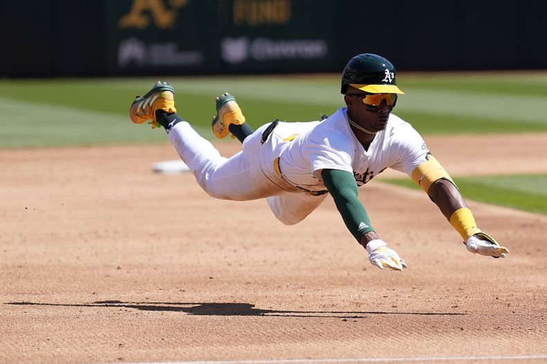 Esteury Ruiz, de los Atléticos de Oakland, se barre en la antesala después de batear un triple durante la tercera entrada del juego de béisbol en contra de los Guardianes de Cleveland, en Oakland, California, el domingo 31 de marzo de 2024. (AP Foto/Jeff Chiu)