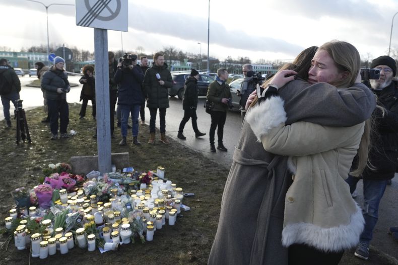 Un grupo de personas se congregan en un monumento improvisado para recordar a las víctimas de un tiroteo en un centro educativo para adultos, a las afueras de Orebro, Suecia, el 5 de febrero de 2025. (AP Foto/Sergei Grits)