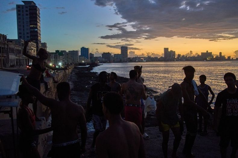 Gente observa el atardecer desde el Malecón durante un apagón en La Habana, el lunes 6 de marzo de 2026. (AP Foto/Ramón Espinosa)