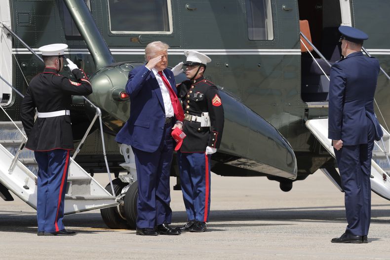 El presidente de EEUU, Donald Trump (segundo de la izquierda), saluda a militares tras bajar del helicóptero Marine One para abordar el avión Air Force One el martes 29 de abril de 2025 en la Base Conjunta Andrews, en Maryland. (AP Foto/Luis M. Alvarez)