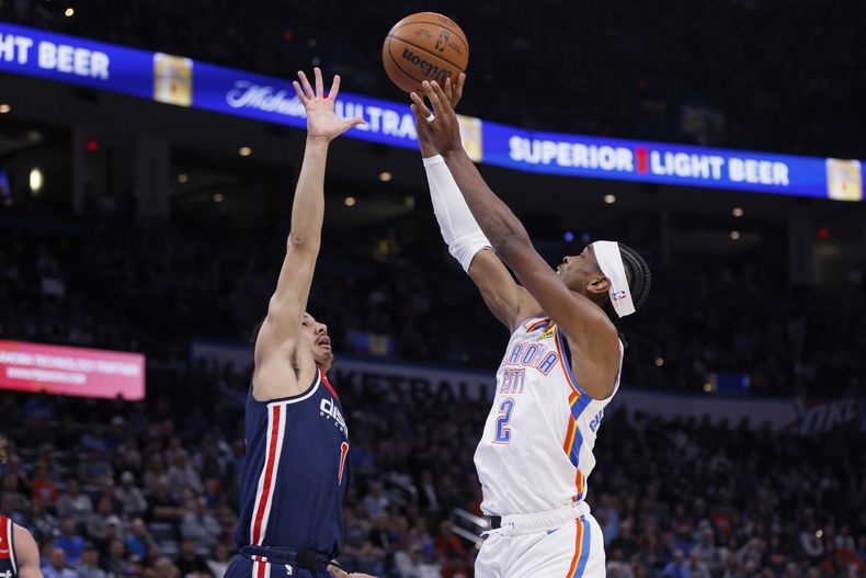 Shai Gilgeous-Alexander, del Thunder de Oklahoma City, dispara frente a Johnny Davis, de los Wizards de Washington, en el encuentro del viernes 23 de febrero de 2024 (AP Foto/Nate Billings)