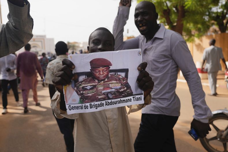 Nigerinos participan en una marcha convocada por simpatizantes del líder de la junta militar, el general Abdourahmane Tchiani, quien aparece en la fotografía, el 30 de julio de 2023, en Niamey, Níger. (AP Foto/Sam Mednick, Archivo)