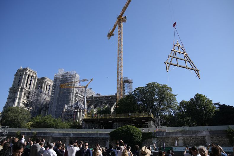 Una grúa levanta un enorme marco de roble en la catedral de Notre Dame de París, el martes 11 de julio de 2023 en París. Los paneles se volverán a montar en la parte superior de Notre Dame para reemplazar el techo que las llamas convirtieron en cenizas en 2019. (Foto AP/Christophe Ena)