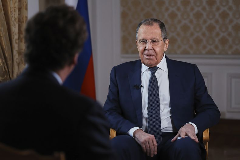 En esta imagen, distribuida por la oficina de prensa del Ministerio de Exteriores de Rusia, el ministro, Sergey Lavrov, habla durante una entrevista con el exconductor de la televisora estadounidense Fox News Tucker Carlson (de espaldas a la cámara), en Moscú, el 3 de diciembre de 2024. (Oficina de prensa del Ministerio de Exteriores de Rusia vía AP)