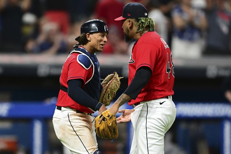 El cerrador dominicano Emmanue Clase, derecha, celebra junto al receptor Bo Naylor la victoria de los Guardianes de Cleveland sobre los Atléticos de Oakland, por 7-6, en partido jugado este miércoles 21 de junio de 2023. (AP Photo/David Dermer)
