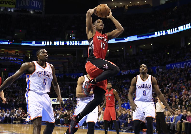 El jugador de los Raptors, DeMar DeRozan, centro, intenta una clavada en un partido contra el Thunder de Oklahoma City el domingo, 22 de diciembre de 2013, en Oklahoma City. (AP Photo/Alonzo Adams)