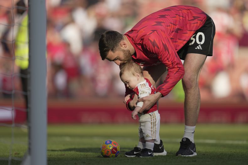 El arquero de Arsenal Matt Turner juega con su hijo tras el partido contra Wolverhampton en la Liga Premier, el domingo 28 de mayo de 2023. (AP Foto/Kin Cheung)