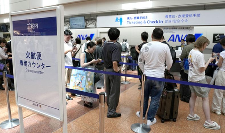 Pasajeros hacen fila frente al mostrador de All Nippon Airways, el martes 11 de agosto de 2026, en el Aeropuerto Internacional de Haneda, en Tokio. (Katsuya Miyagawa/Kyodo News via AP)