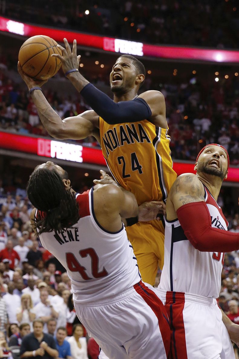 El alero de los Pacers de Indiana Paul George (24) dispara al aro entre los jugadores de los Wizards de Washington Nene (42) y Drew Gooden durante la segunda mitad del 4to partido de la semifinal de la Conferencia Este de la NBA, el domingo, 11 de abril d