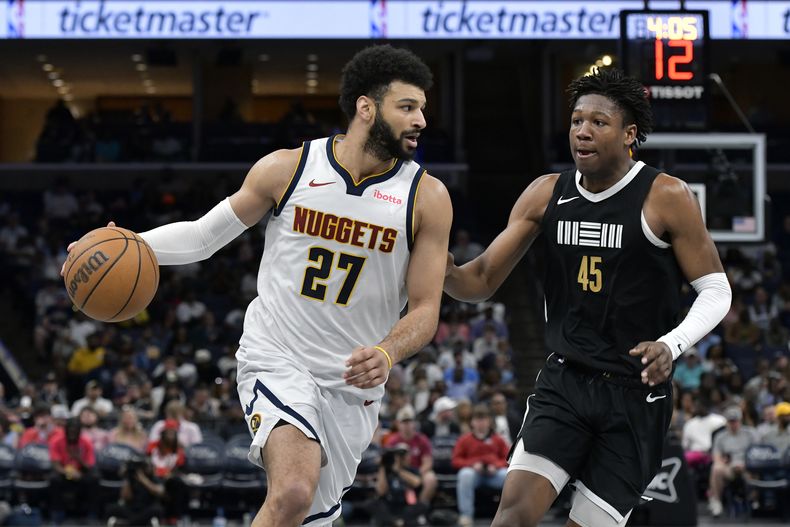 El armador de los Nuggets de Denver Jamal Murray (27) conduce el balón ante el alero de los Grizzlies de Memphis GG Jackson (45) en la segunda mitad del juego de baloncesto de la NBA, el domingo 14 de abril de 2024, en Memphis, Tennessee. (AP Foto/Brandon Dill)